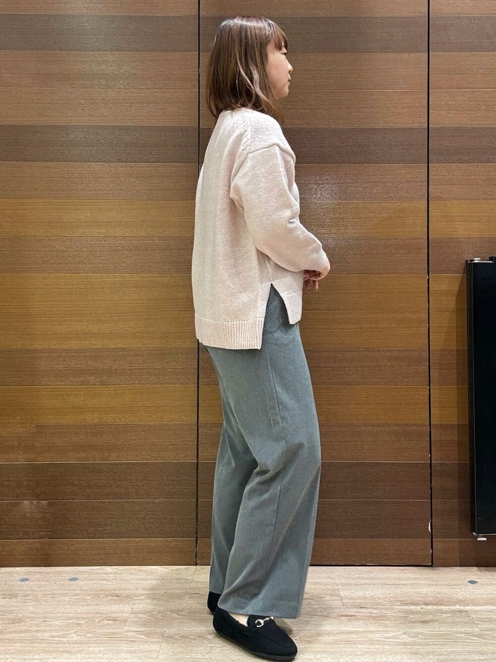 ピンク系のニット/セーター、グレー系のその他パンツ、ブラック系のパンプスを着用したレディースの冬コーディネートの7枚目の写真