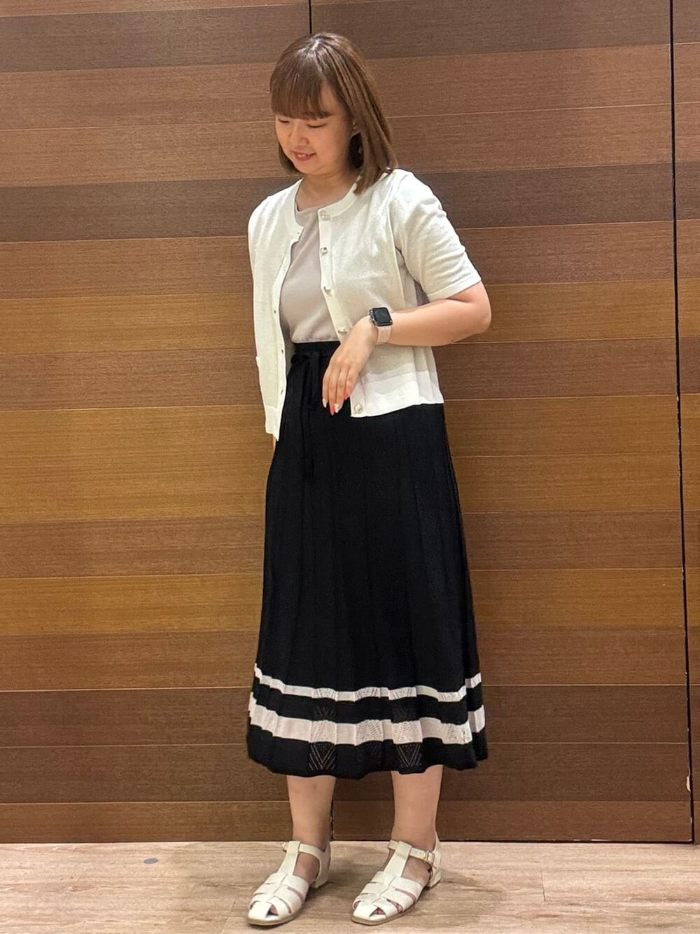 ゴールド系のカーディガン/ボレロ、ブラック系のワンピース、ベージュ系のトートバッグを着用したレディースの夏コーディネートの3枚目の写真