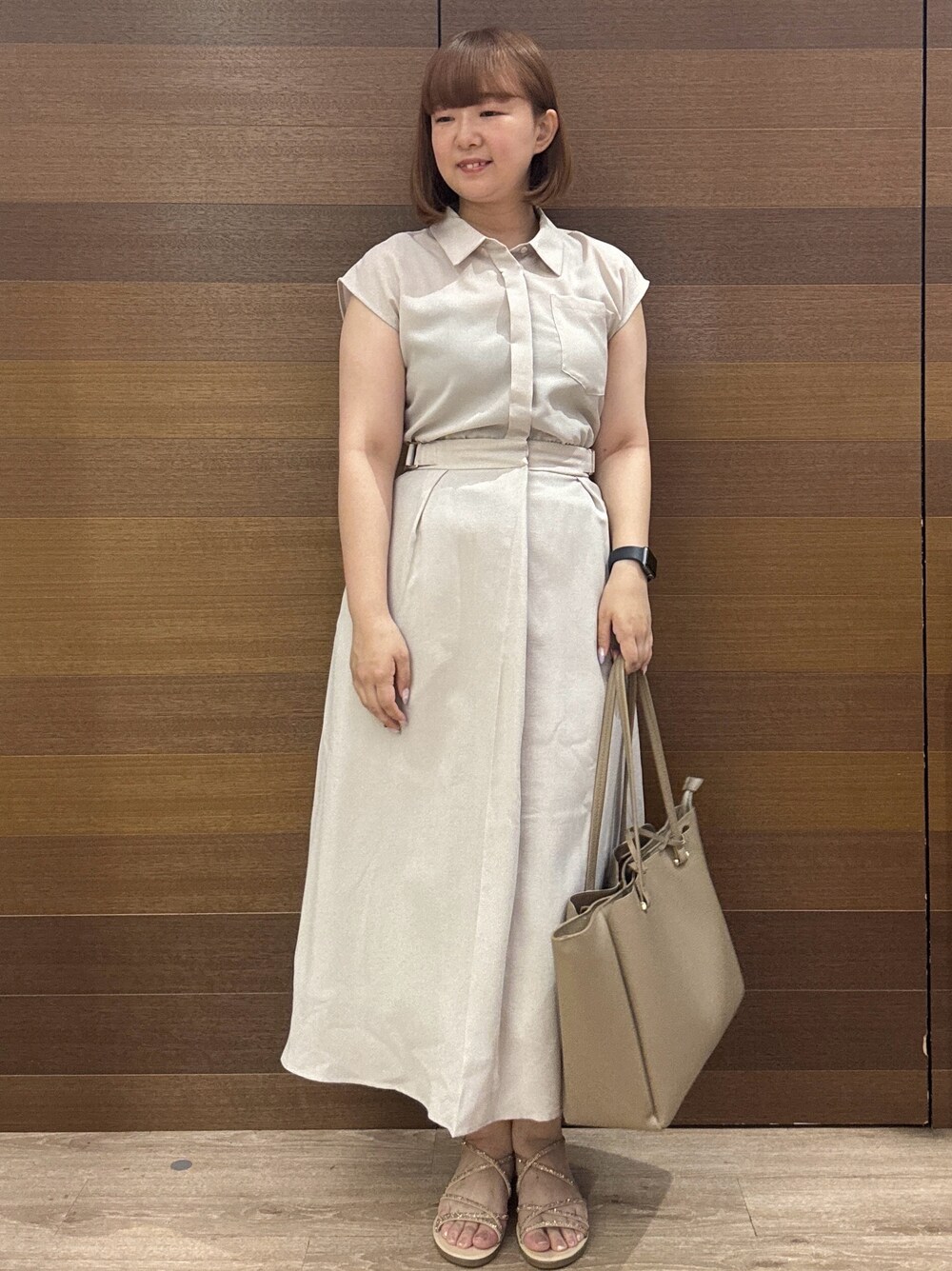 ベージュ系のワンピース、グレー系のトートバッグ、ゴールド系のサンダルを着用したレディースの夏コーディネートの2枚目の写真