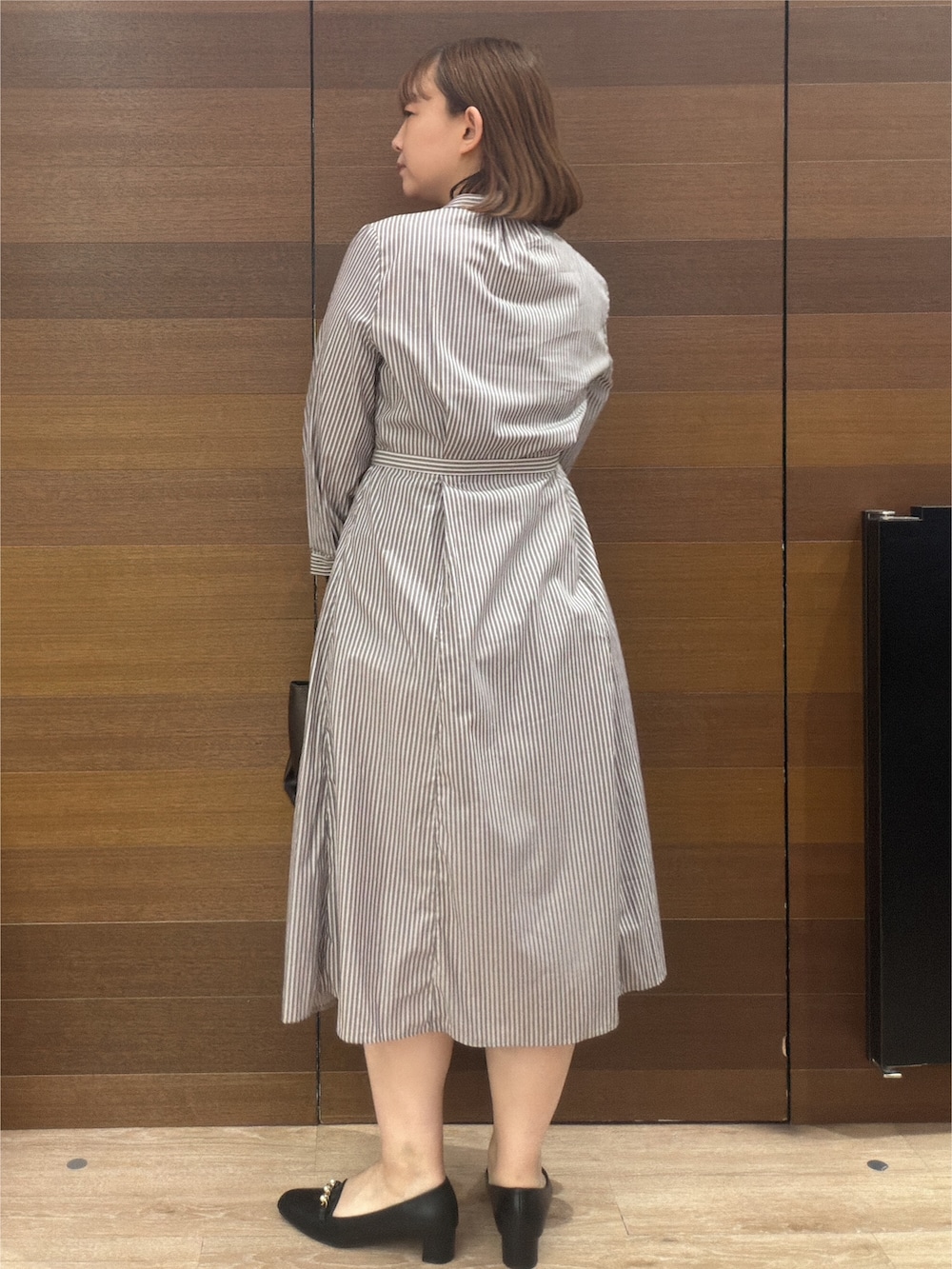 ブラウン系のワンピース、その他のトートバッグ、ブラック系のパンプスを着用したレディースの秋コーディネートの6枚目の写真