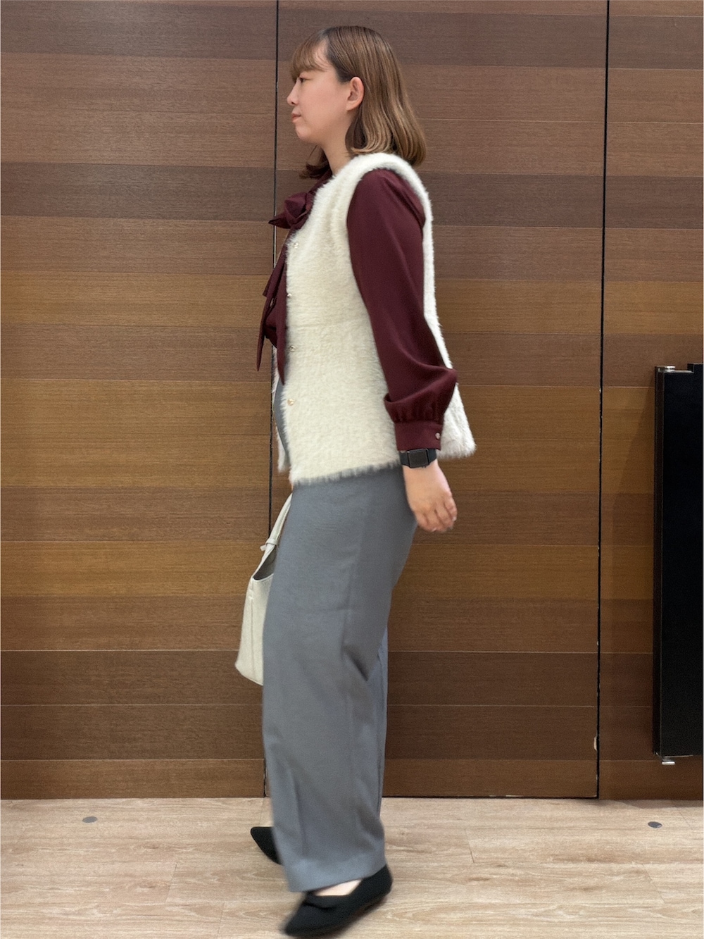 ベージュ系のベスト、レッド系のシャツ/ブラウス、グレー系のその他パンツを着用したレディースの秋コーディネートの5枚目の写真