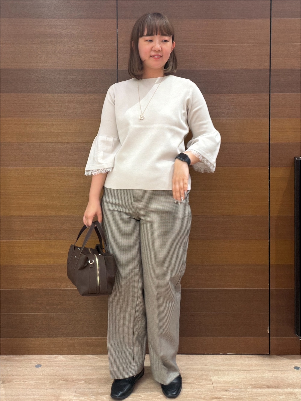 ベージュ系のニット/セーター、ブラウン系のその他パンツ、ブラウン系のボストンバッグを着用したレディースの秋コーディネートの3枚目の写真