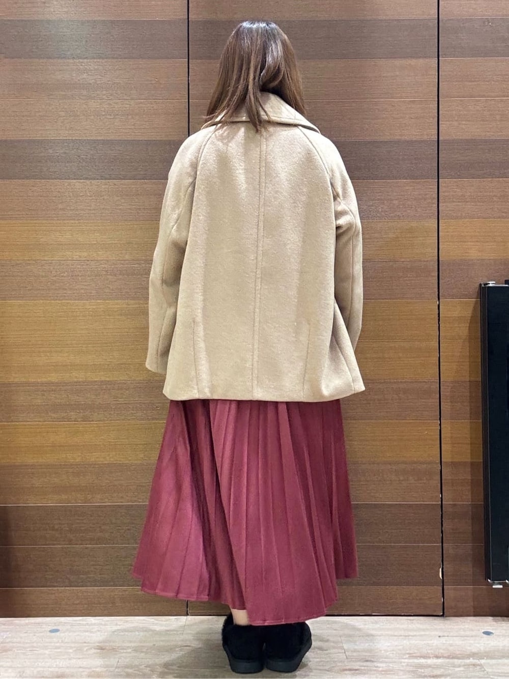 ベージュ系のピーコート、ホワイト系のニット/セーター、レッド系のスカートを着用したレディースの冬コーディネートの6枚目の写真