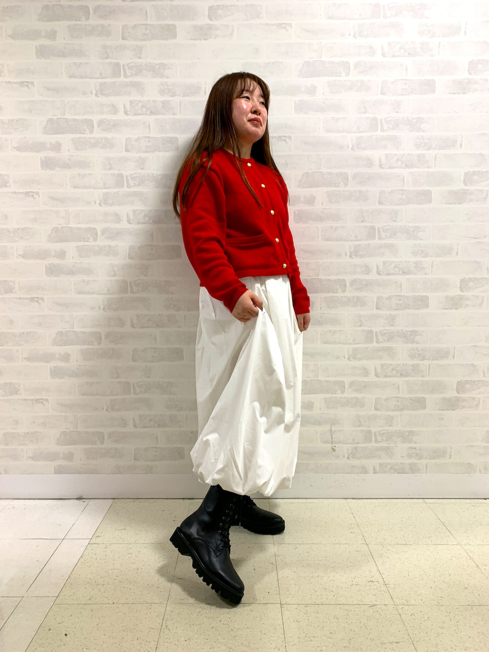 ブラック系のブルゾン、レッド系のカーディガン/ボレロ、ブラック系のブーツを着用したレディースの冬コーディネートの2枚目の写真