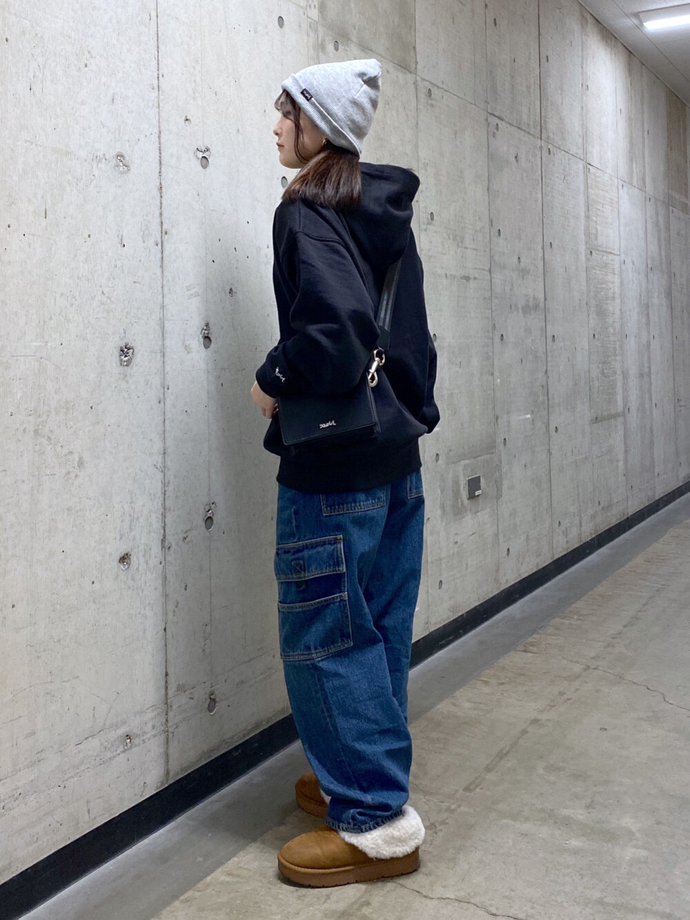 ブラック系のパーカー、ブルー系のカーゴパンツ、ブラック系のショルダーバッグを着用したレディースの冬コーディネートの3枚目の写真