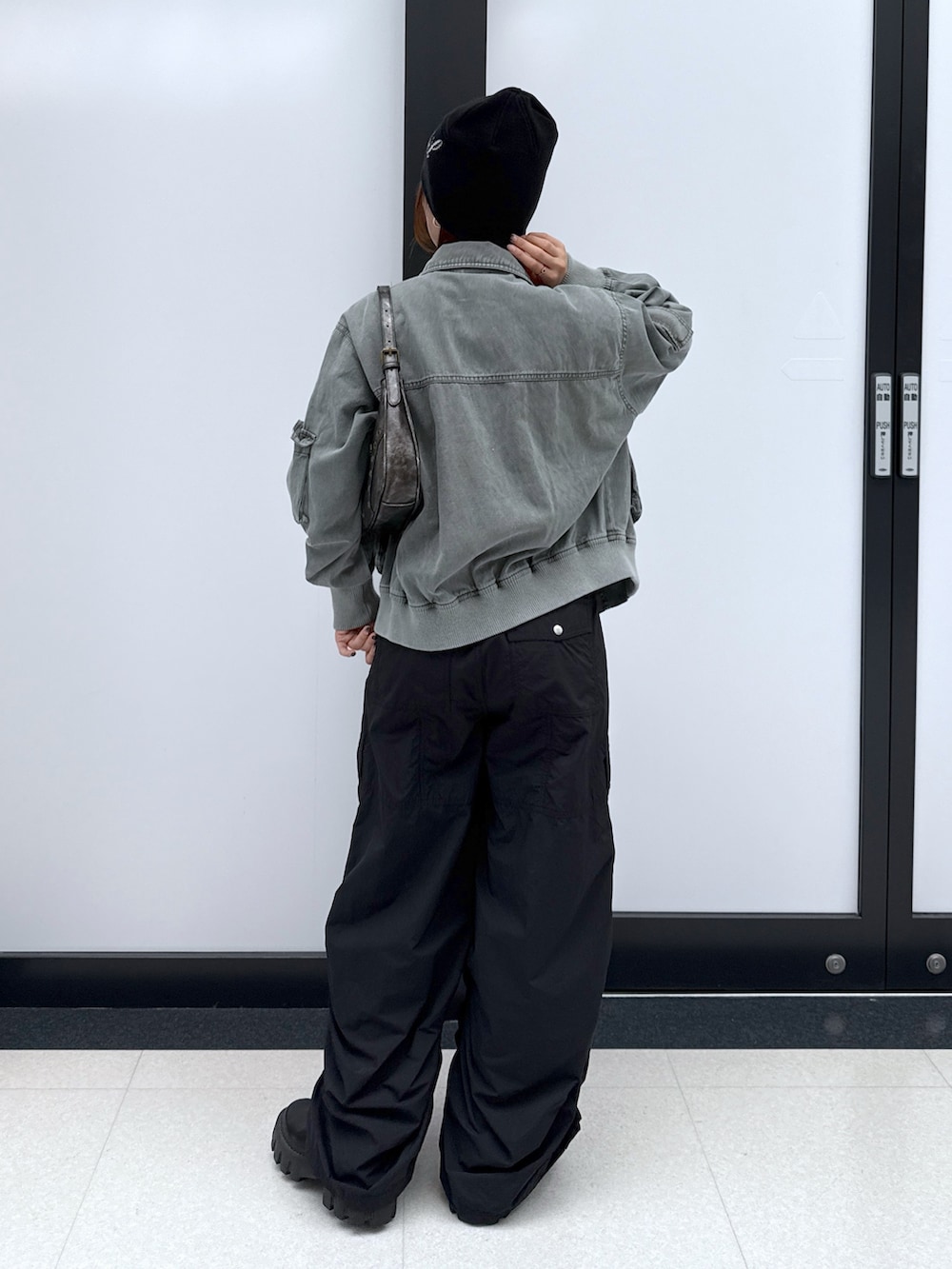 ブラック系のカーゴパンツ、ゴールド系のハンドバッグ、ブラック系のTシャツ/カットソーを着用したレディースの秋コーディネートの3枚目の写真