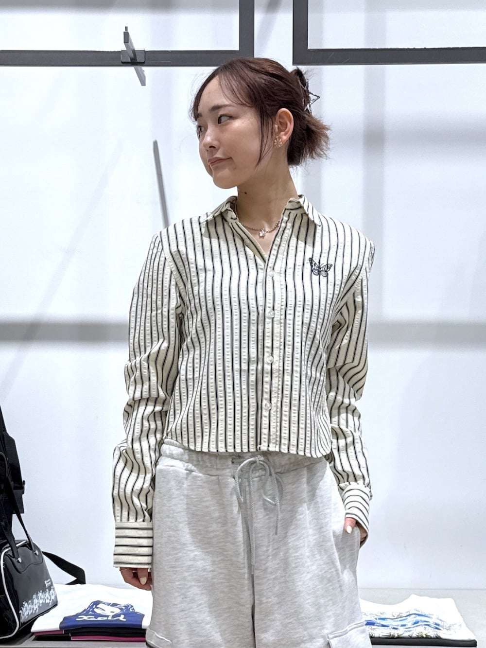 グレー系のスウェットパンツ、ブラック系のハンドバッグ、ホワイト系のシャツ/ブラウスを着用したレディースの夏コーディネートの2枚目の写真