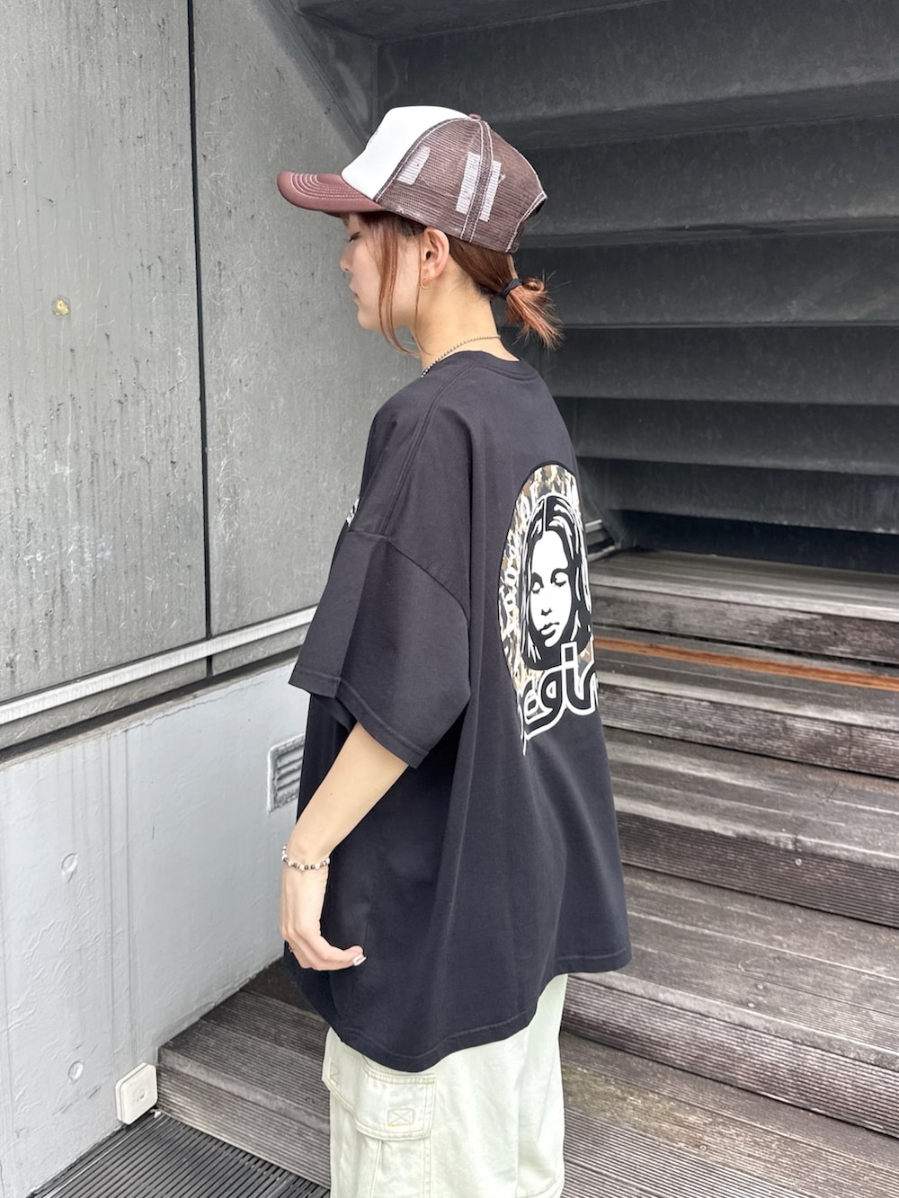 ブラック系のワンピース、ブルー系のデニムパンツ、ベージュ系のショルダーバッグを着用したレディースの夏コーディネートの5枚目の写真