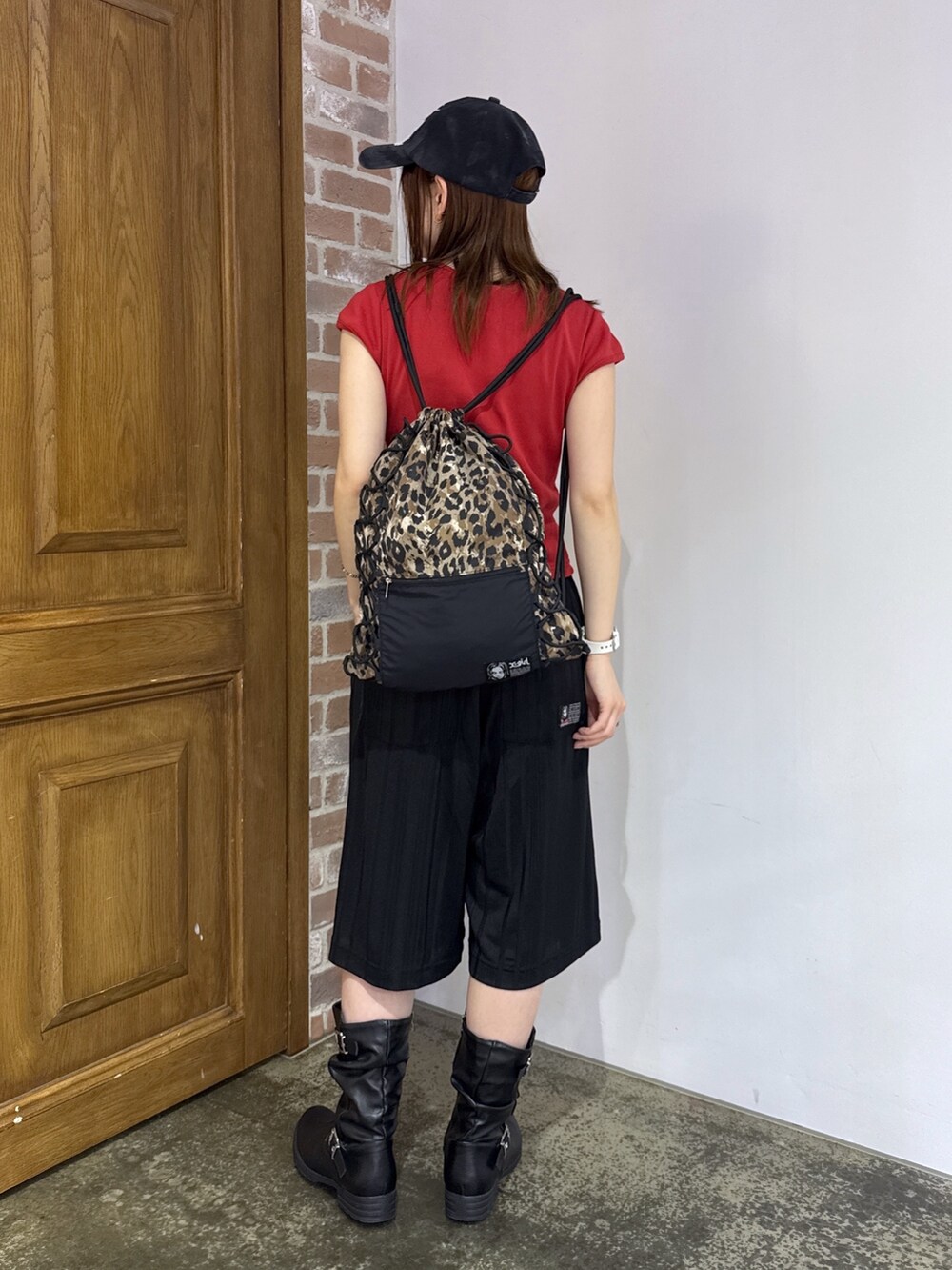 ブラック系のその他パンツ、ベージュ系のバックパック/リュック、レッド系のTシャツ/カットソーを着用したレディースの夏コーディネートの3枚目の写真