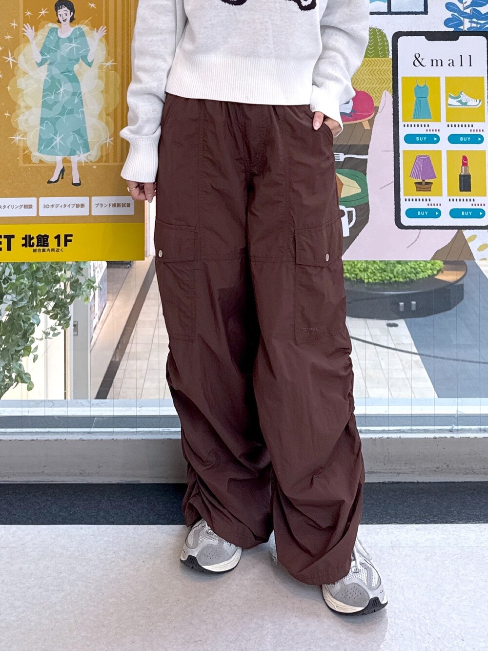 ホワイト系のニット/セーター、ブラウン系のカーゴパンツ、ブラック系のハンドバッグを着用したレディースの秋コーディネートの5枚目の写真