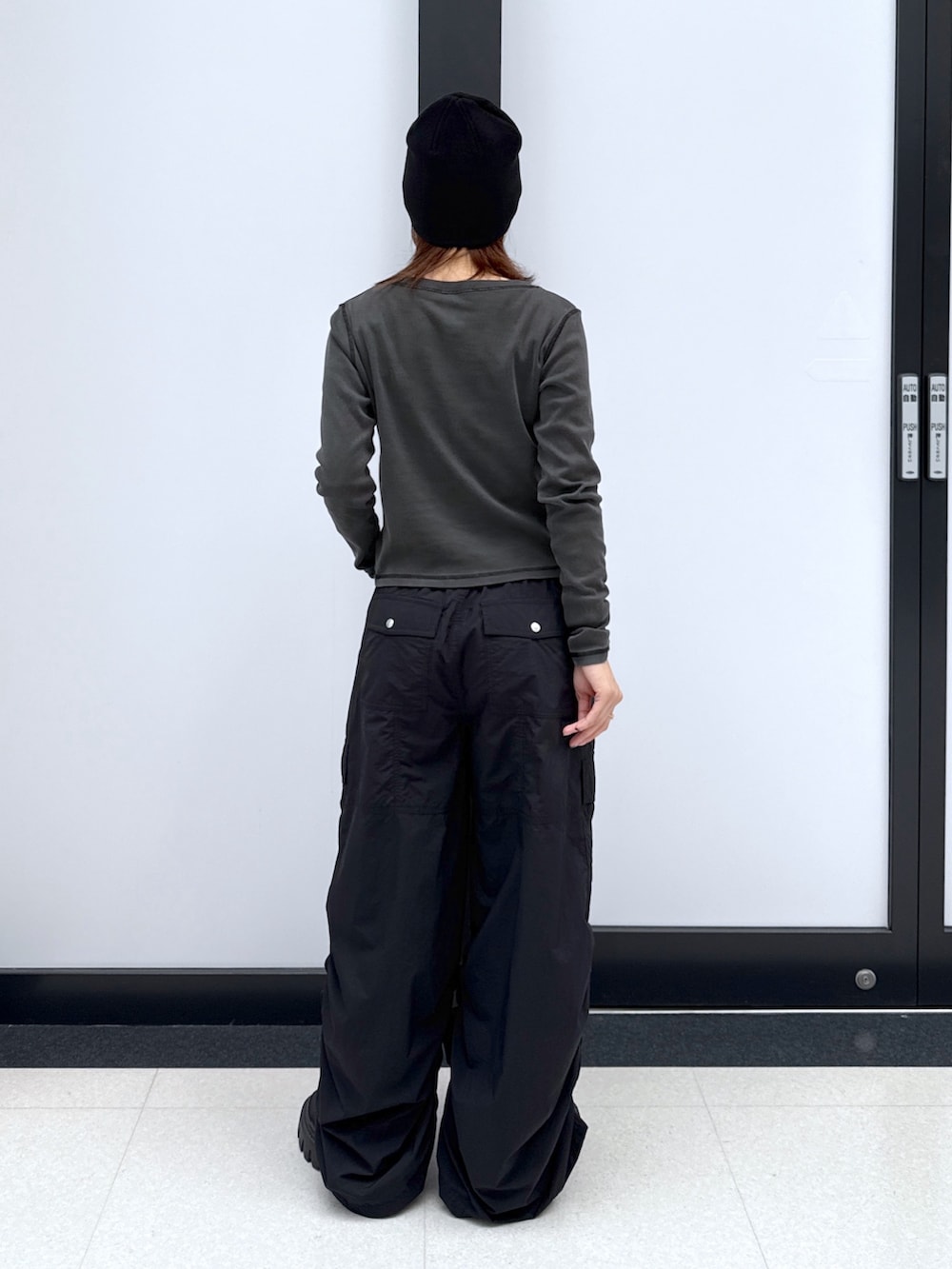 ブラック系のカーゴパンツ、ゴールド系のハンドバッグ、ブラック系のTシャツ/カットソーを着用したレディースの秋コーディネートの9枚目の写真