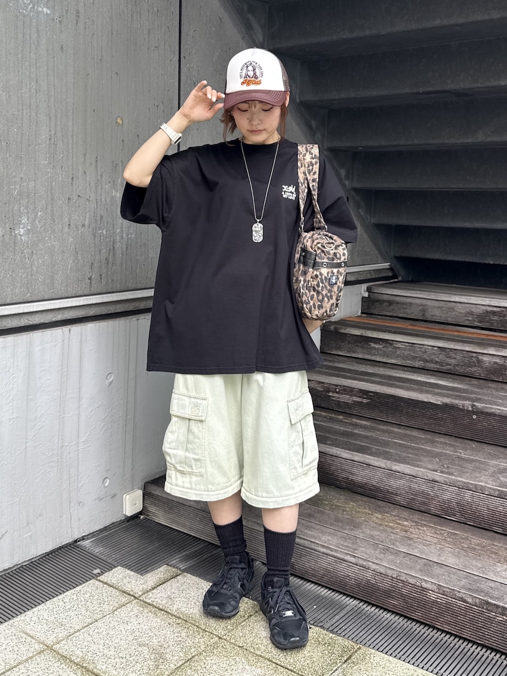 ブラック系のワンピース、ブルー系のデニムパンツ、ベージュ系のショルダーバッグを着用したレディースの夏コーディネートの2枚目の写真
