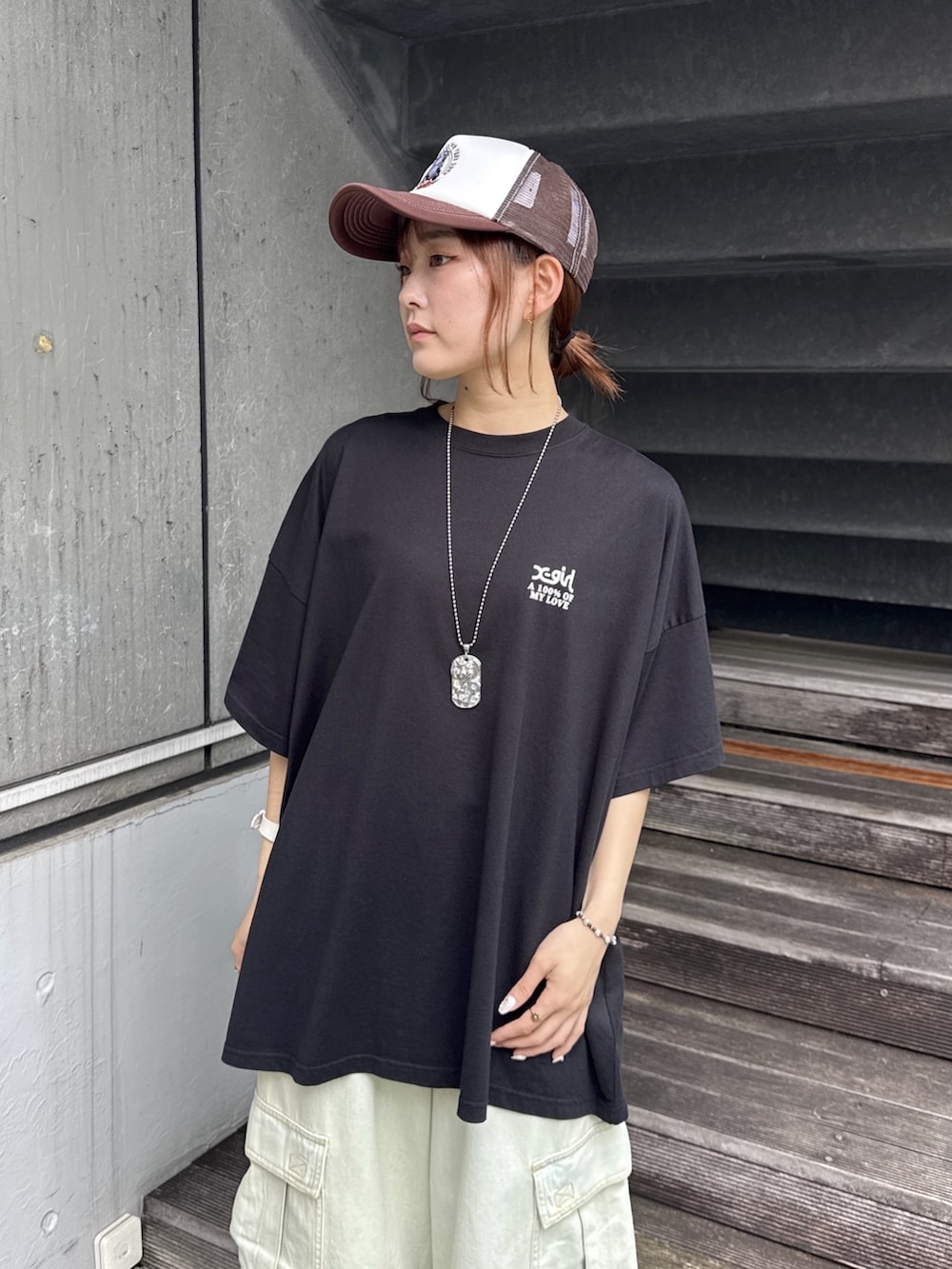 ブラック系のワンピース、ブルー系のデニムパンツ、ベージュ系のショルダーバッグを着用したレディースの夏コーディネートの4枚目の写真