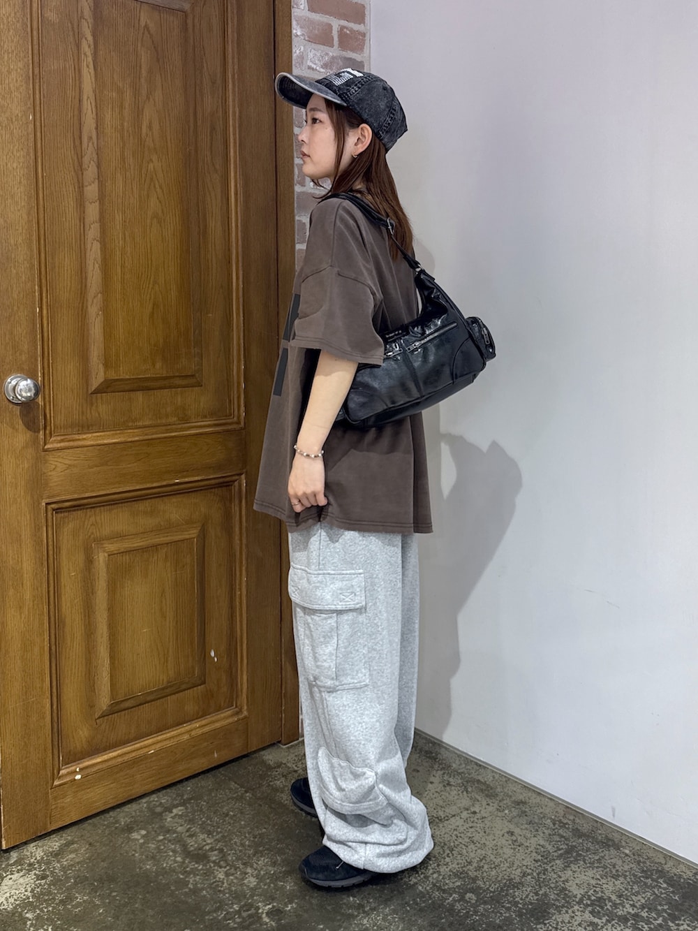ブラウン系のワンピース、グレー系のスウェットパンツ、ブラック系のショルダーバッグを着用したレディースの夏コーディネートの2枚目の写真