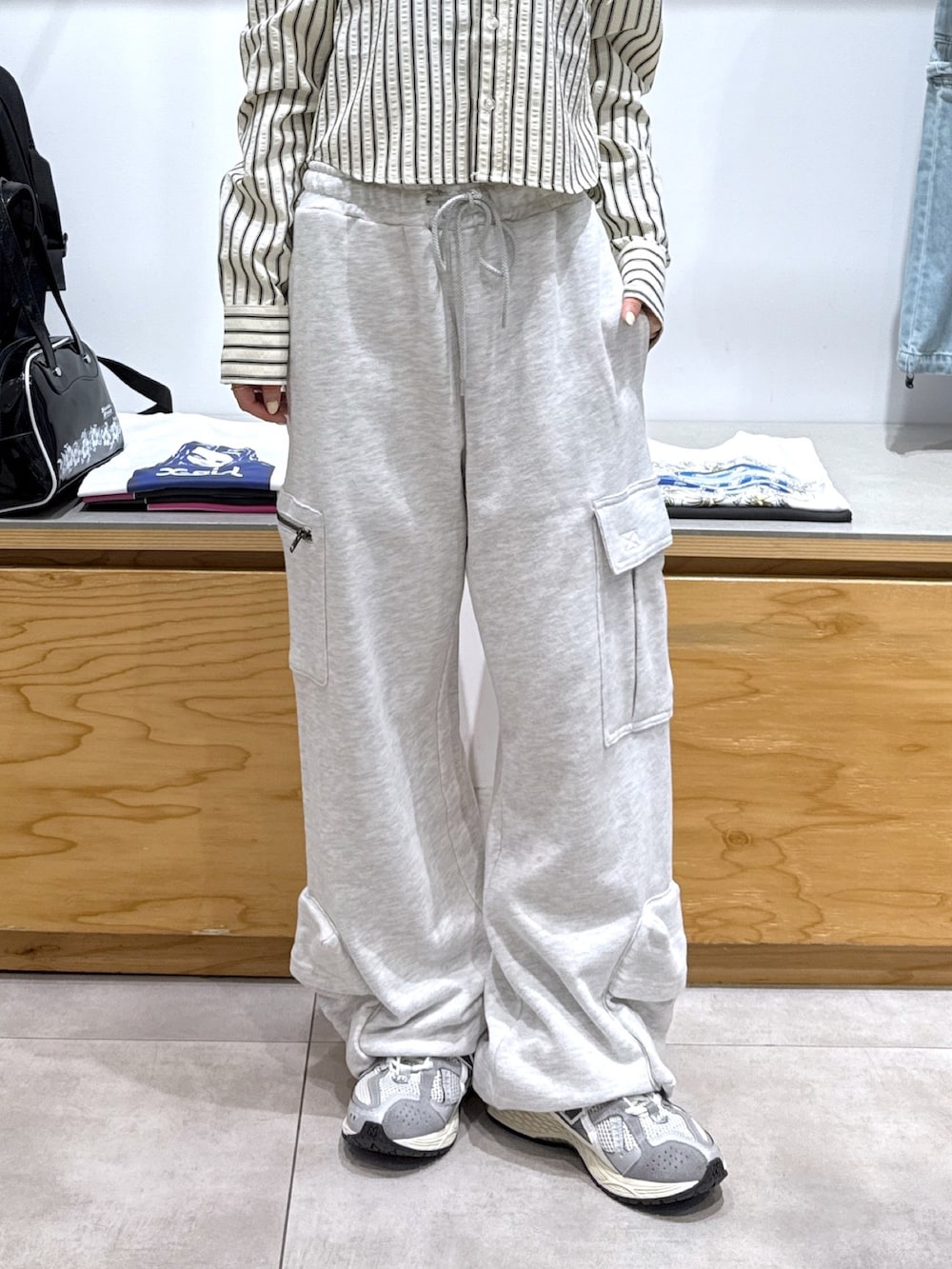 グレー系のスウェットパンツ、ブラック系のハンドバッグ、ホワイト系のシャツ/ブラウスを着用したレディースの夏コーディネートの4枚目の写真