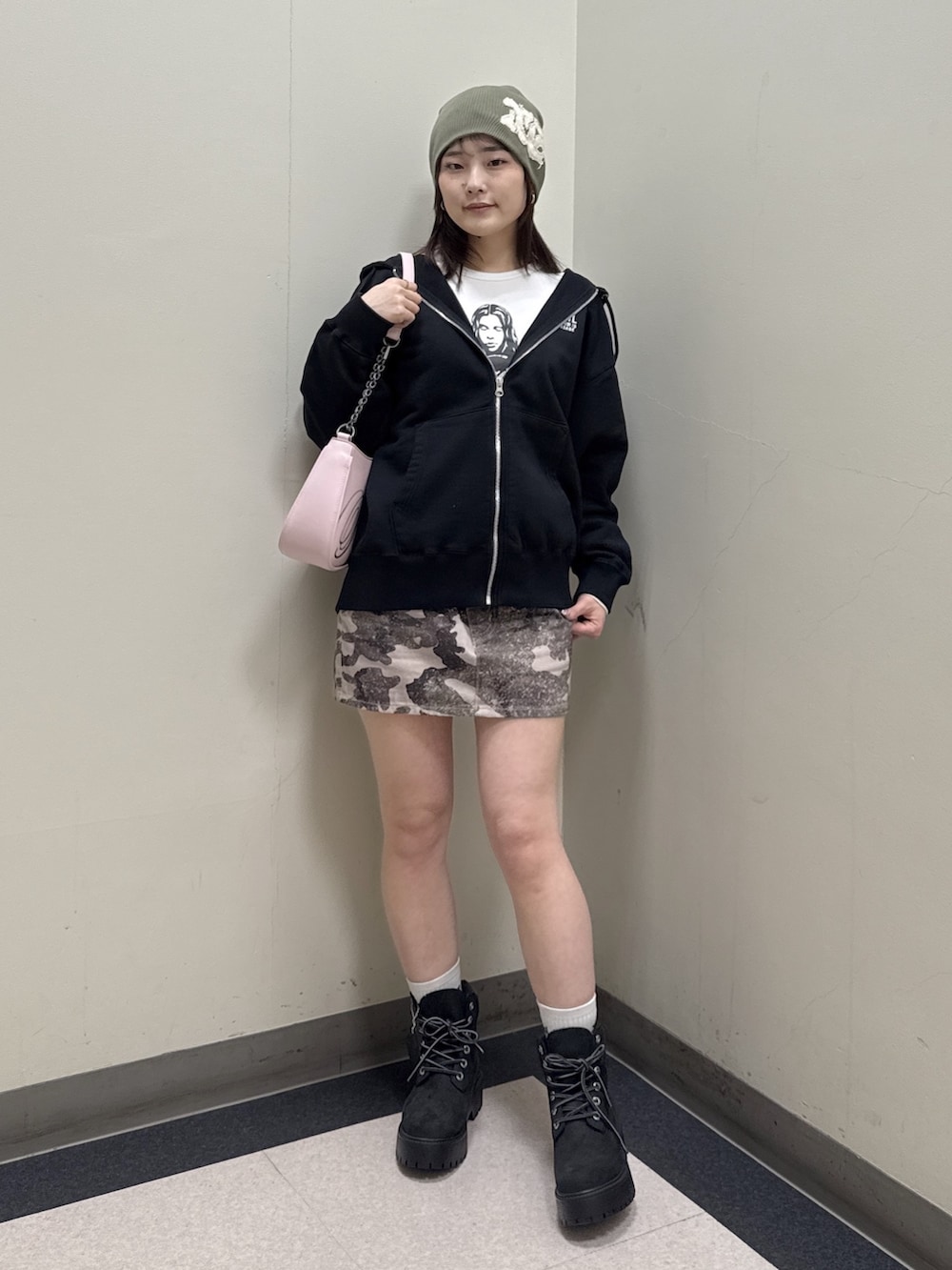 ブラック系のパーカー、その他のスカート、ピンク系のショルダーバッグを着用したレディースの冬コーディネートの2枚目の写真