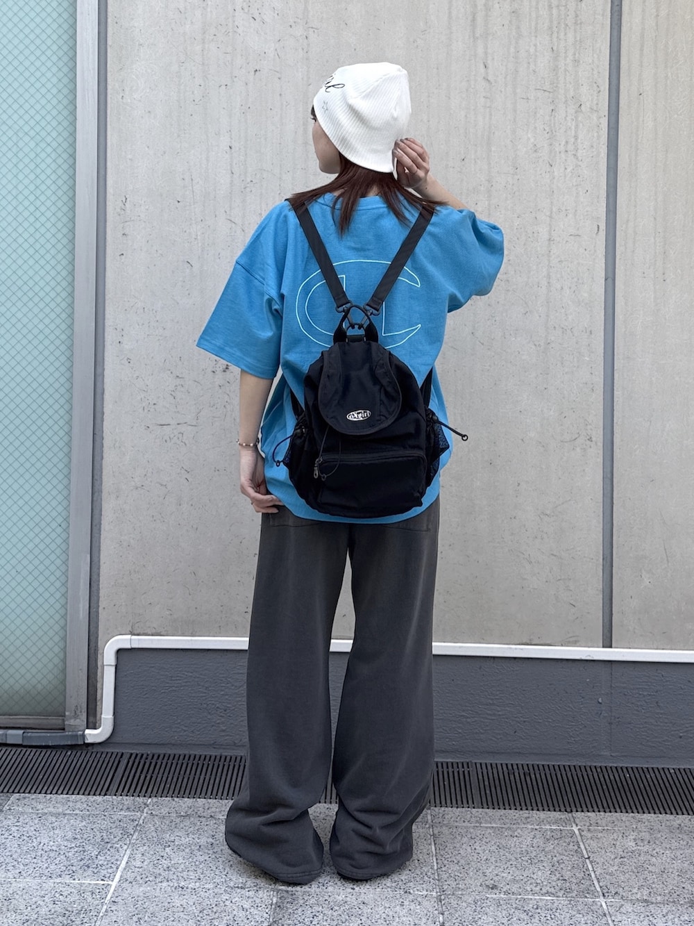 ブラック系のスウェットパンツ、ブルー系のTシャツ/カットソー、ブラック系のバックパック/リュックを着用したレディースの春コーディネートの3枚目の写真