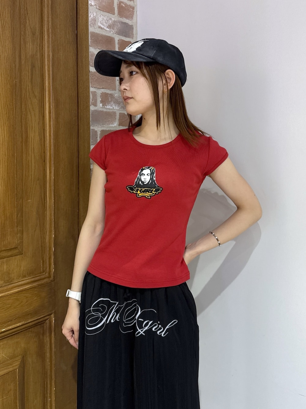 ブラック系のその他パンツ、ベージュ系のバックパック/リュック、レッド系のTシャツ/カットソーを着用したレディースの夏コーディネートの4枚目の写真