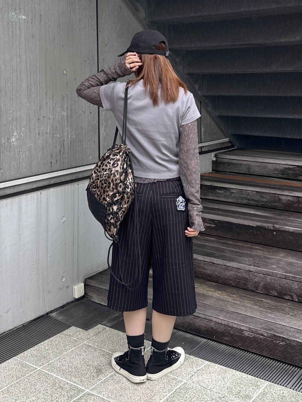 グレー系のTシャツ/カットソー、ブラック系のその他パンツ、ベージュ系のバックパック/リュックを着用したレディースの秋コーディネートの3枚目の写真