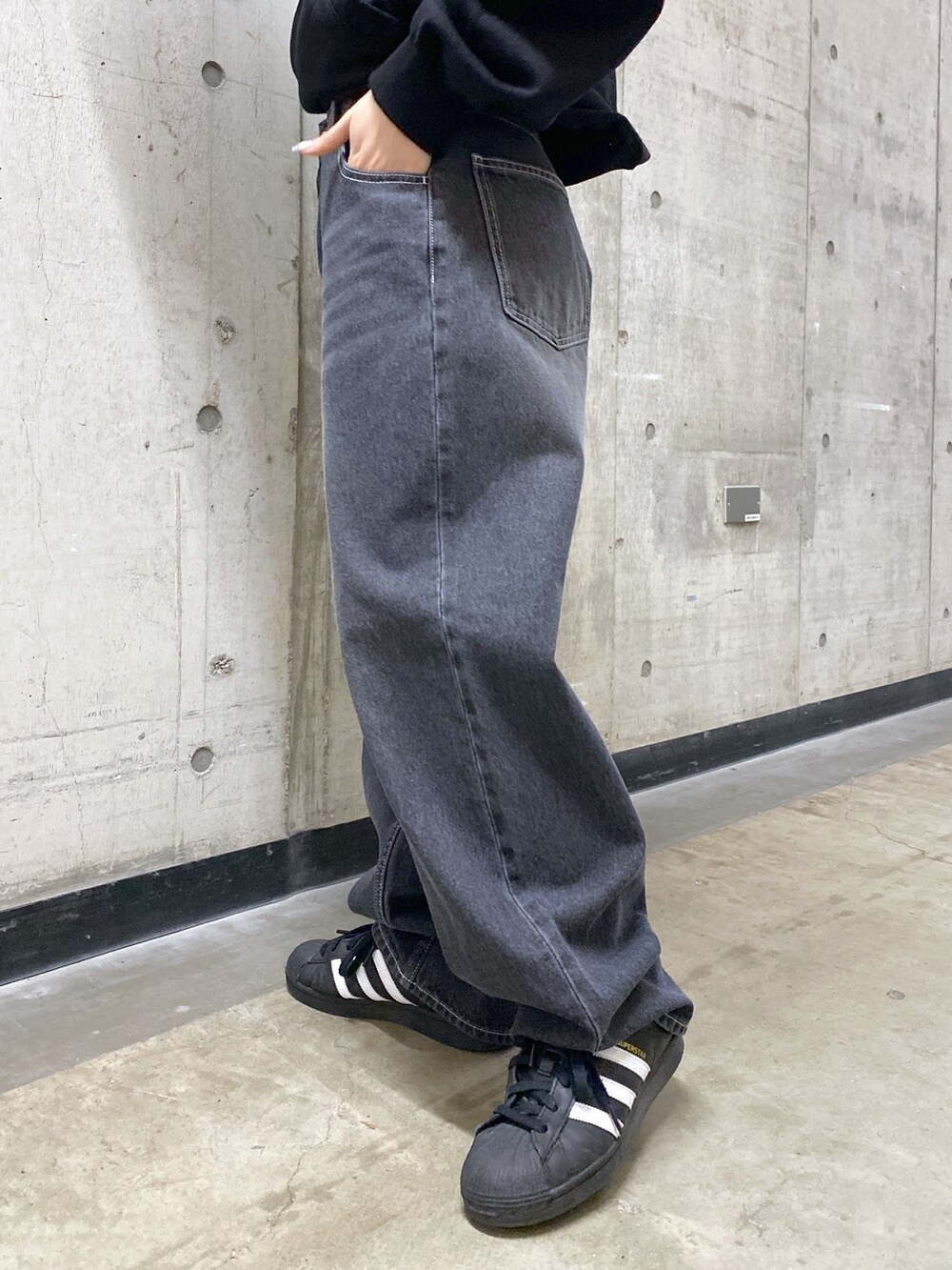 ブラック系のパーカー、ブラック系のデニムパンツ、グレー系のニットキャップ/ビーニーを着用したレディースの冬コーディネートの6枚目の写真