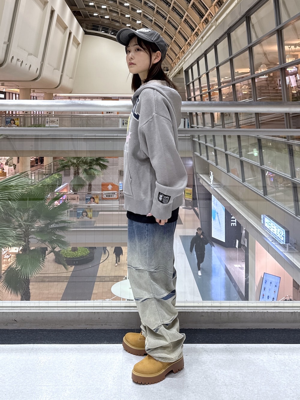 ブラック系のTシャツ/カットソー、グレー系のニット/セーター、ブルー系のデニムパンツを着用したレディースの冬コーディネートの2枚目の写真