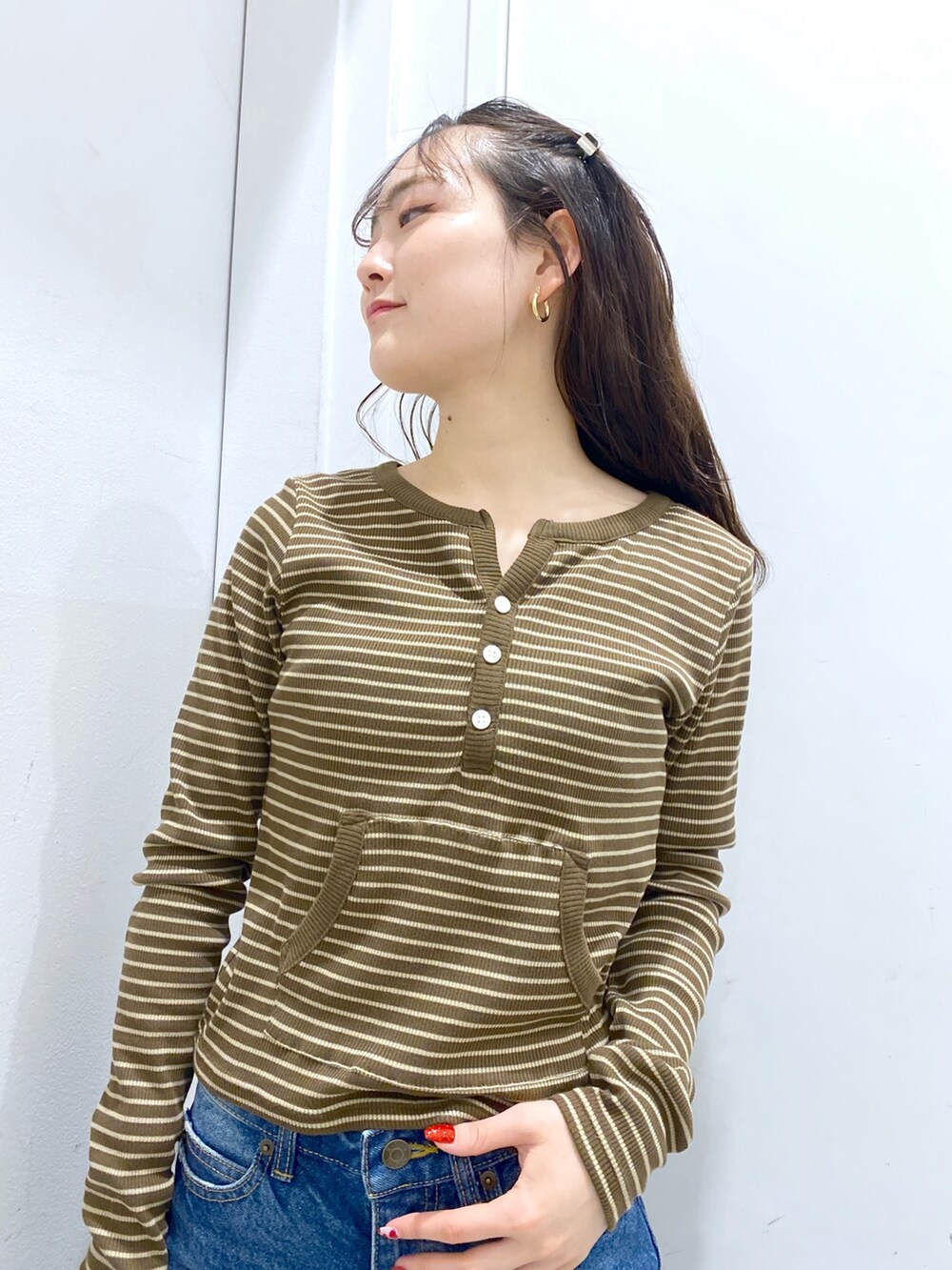 ブラウン系のTシャツ/カットソー、ブルー系のデニムパンツ、ブラック系のショルダーバッグを着用したレディースの冬コーディネートの3枚目の写真