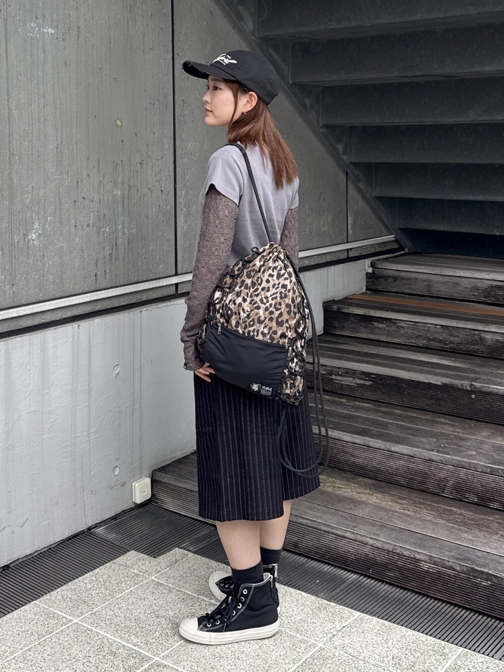 グレー系のTシャツ/カットソー、ブラック系のその他パンツ、ベージュ系のバックパック/リュックを着用したレディースの秋コーディネートの2枚目の写真