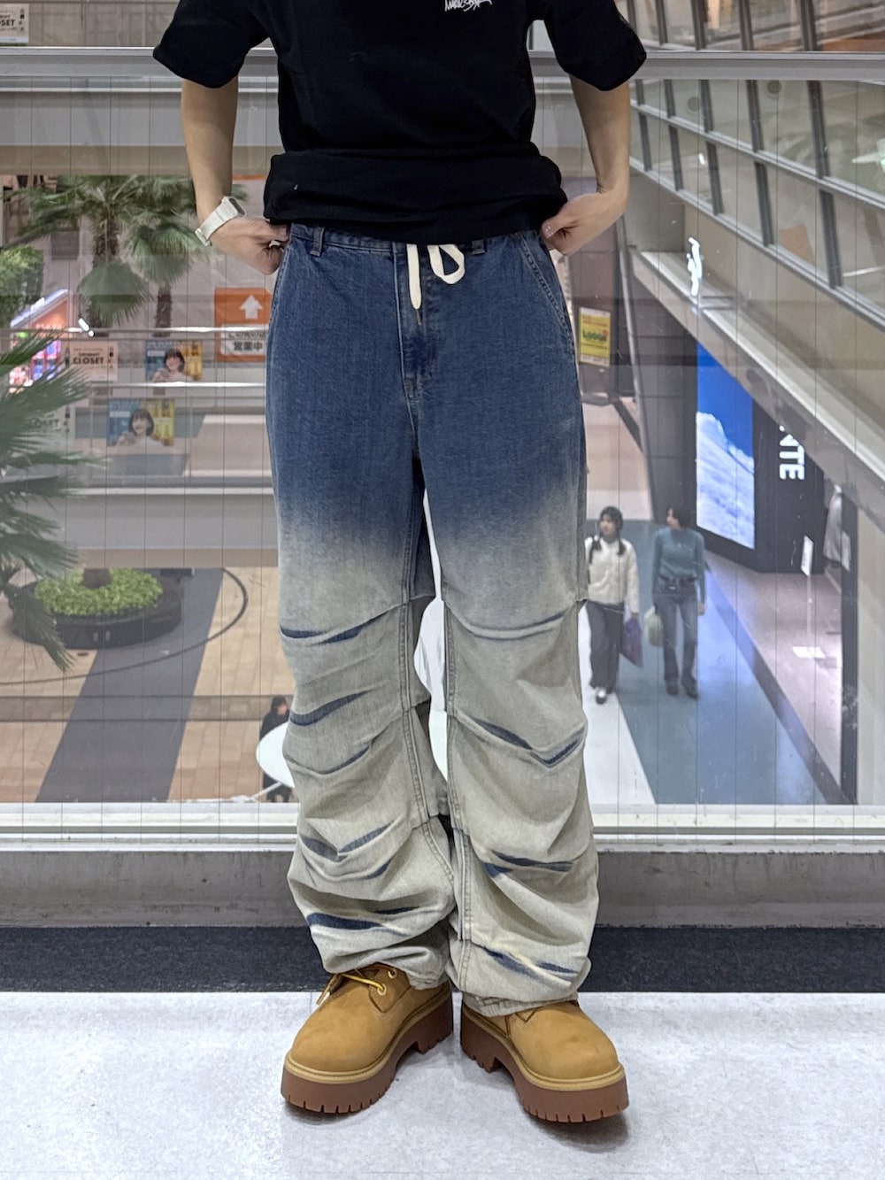 ブラック系のTシャツ/カットソー、グレー系のニット/セーター、ブルー系のデニムパンツを着用したレディースの冬コーディネートの7枚目の写真