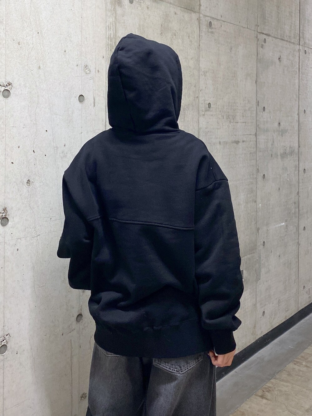 ブラック系のパーカー、ブラック系のデニムパンツ、グレー系のニットキャップ/ビーニーを着用したレディースの冬コーディネートの4枚目の写真