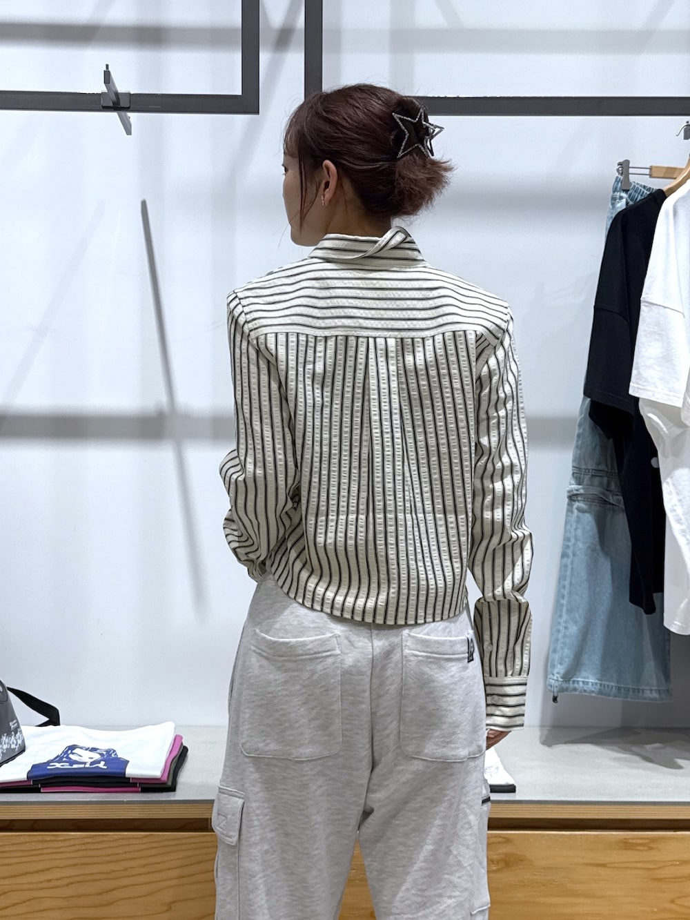 グレー系のスウェットパンツ、ブラック系のハンドバッグ、ホワイト系のシャツ/ブラウスを着用したレディースの夏コーディネートの3枚目の写真