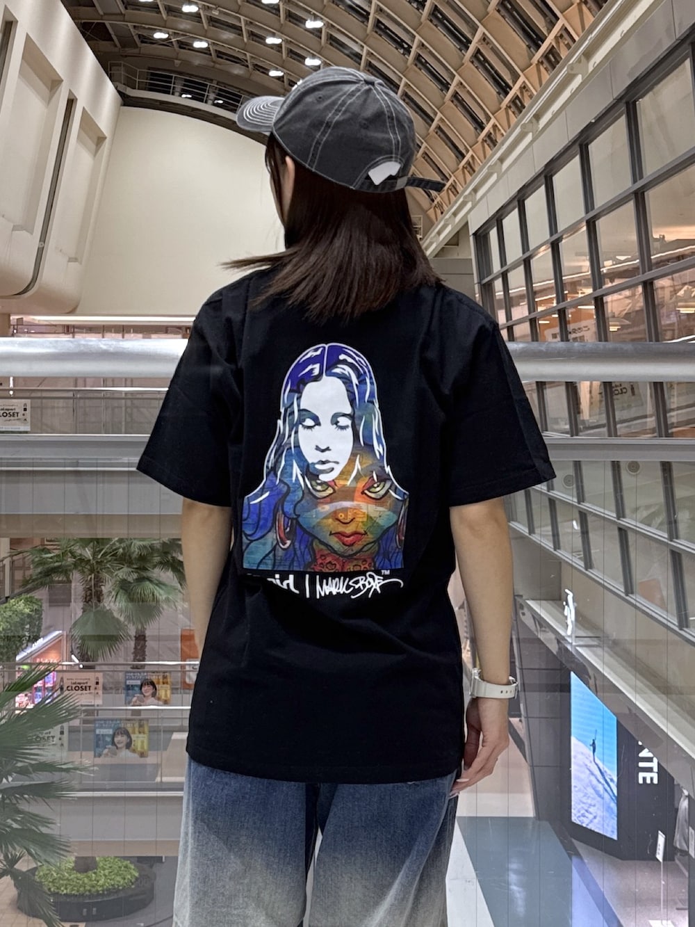 ブラック系のTシャツ/カットソー、グレー系のニット/セーター、ブルー系のデニムパンツを着用したレディースの冬コーディネートの6枚目の写真