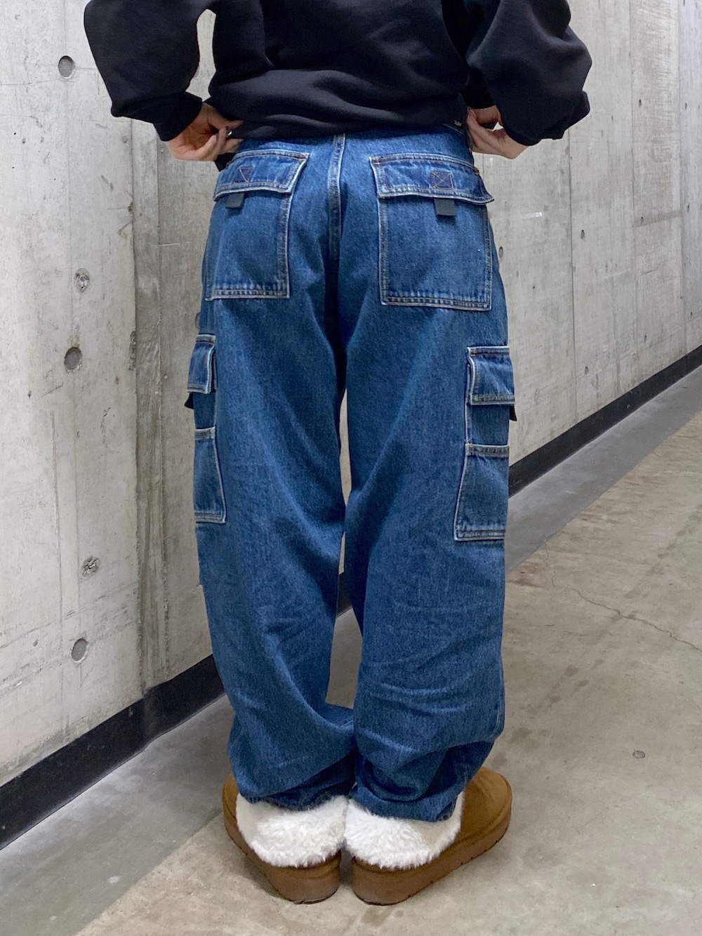 ブラック系のパーカー、ブルー系のカーゴパンツ、ブラック系のショルダーバッグを着用したレディースの冬コーディネートの8枚目の写真