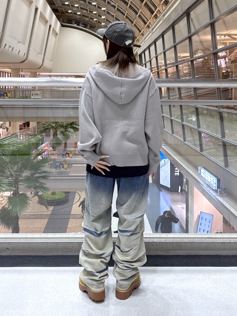 ブラック系のTシャツ/カットソー、グレー系のニット/セーター、ブルー系のデニムパンツを着用したレディースの冬コーディネートの3枚目の写真