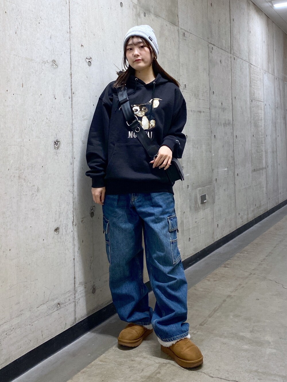 ブラック系のパーカー、ブルー系のカーゴパンツ、ブラック系のショルダーバッグを着用したレディースの冬コーディネートの2枚目の写真