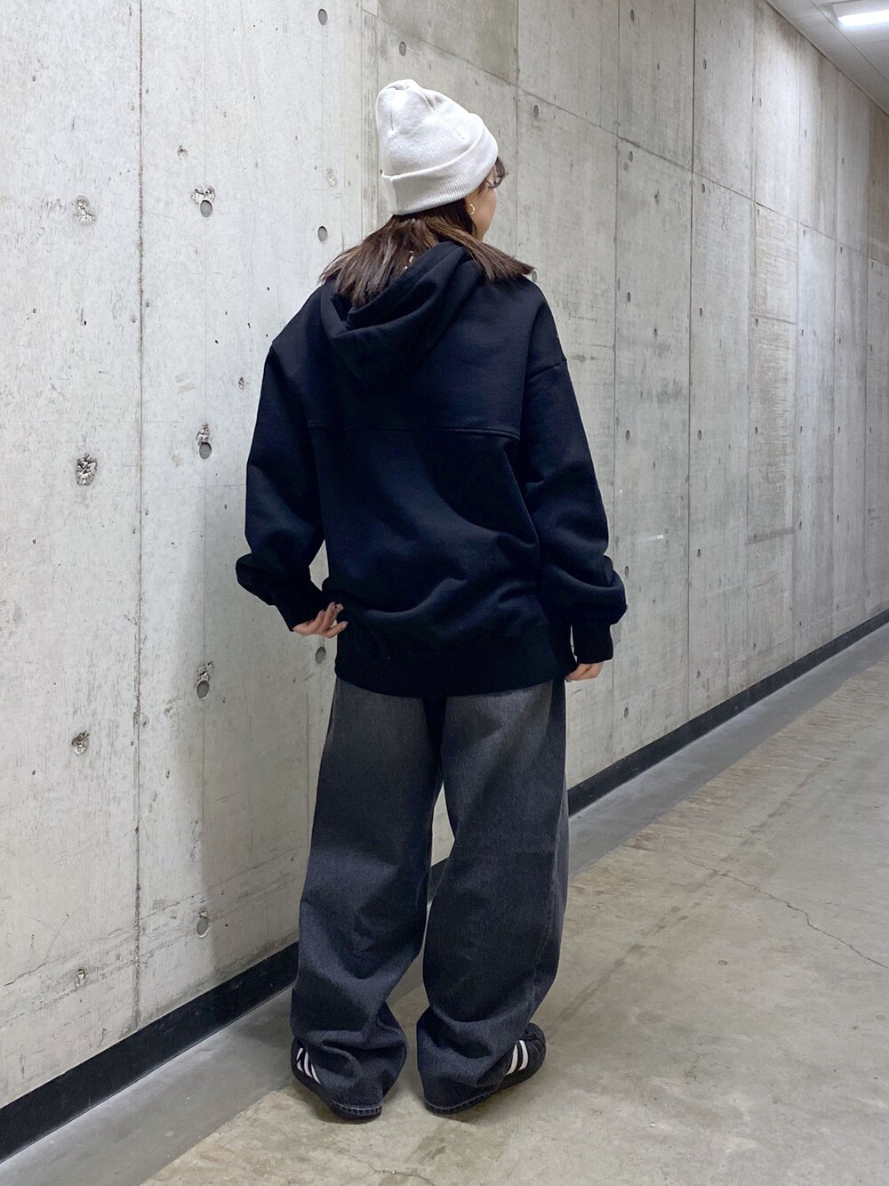 ブラック系のパーカー、ブラック系のデニムパンツ、グレー系のニットキャップ/ビーニーを着用したレディースの冬コーディネートの2枚目の写真