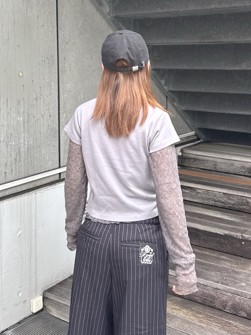 グレー系のTシャツ/カットソー、ブラック系のその他パンツ、ベージュ系のバックパック/リュックを着用したレディースの秋コーディネートの6枚目の写真