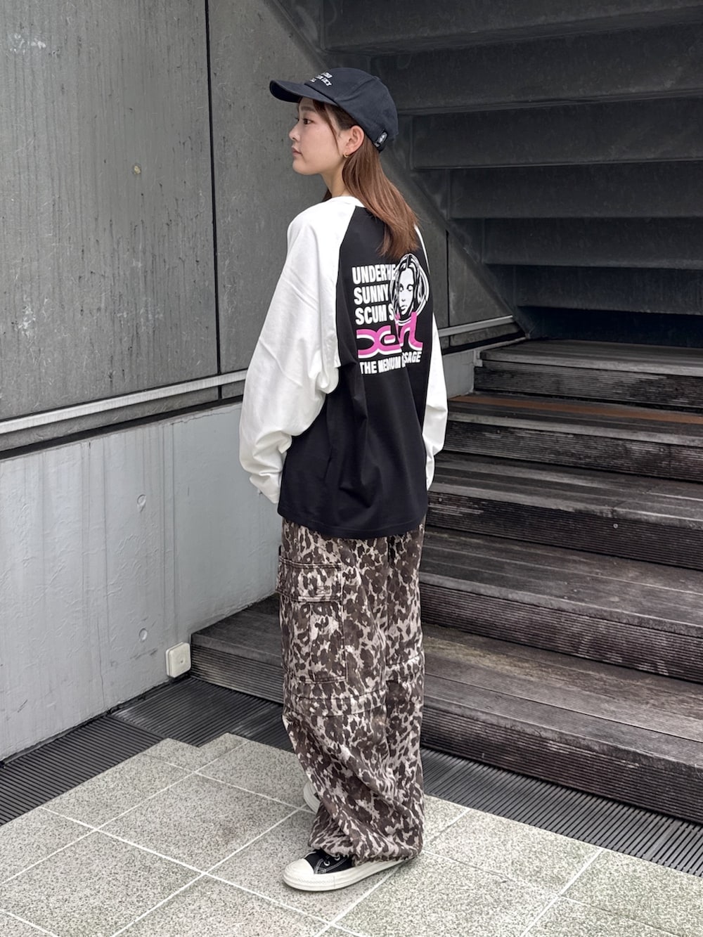 ブラック系のTシャツ/カットソー、ベージュ系のカーゴパンツ、ブラック系のキャップを着用したレディースの秋コーディネートの3枚目の写真