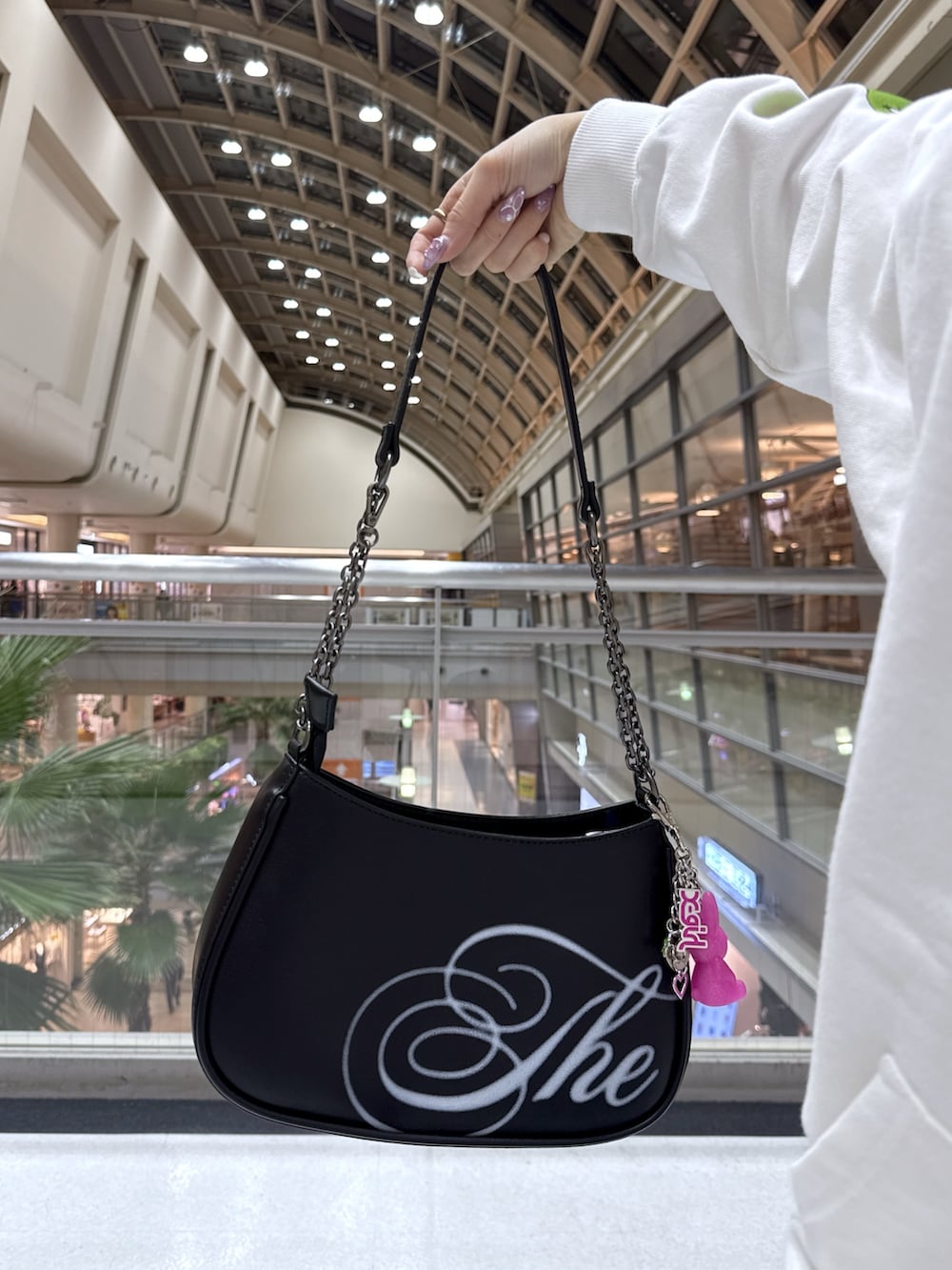 ホワイト系のパーカー、ブルー系のデニムパンツ、ブラック系のショルダーバッグを着用したレディースの冬コーディネートの10枚目の写真