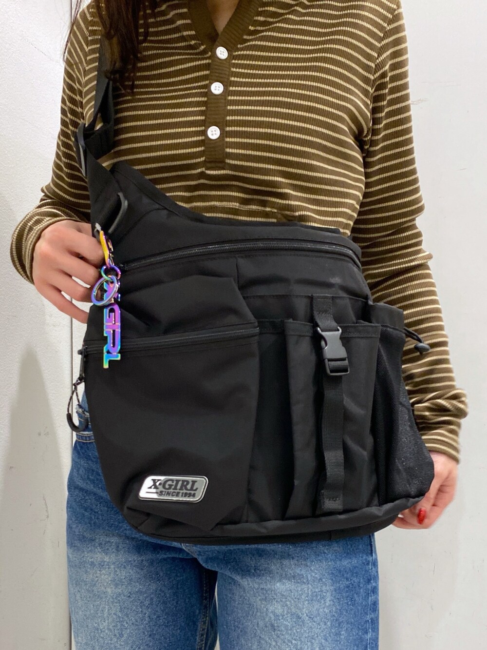 ブラウン系のTシャツ/カットソー、ブルー系のデニムパンツ、ブラック系のショルダーバッグを着用したレディースの冬コーディネートの8枚目の写真