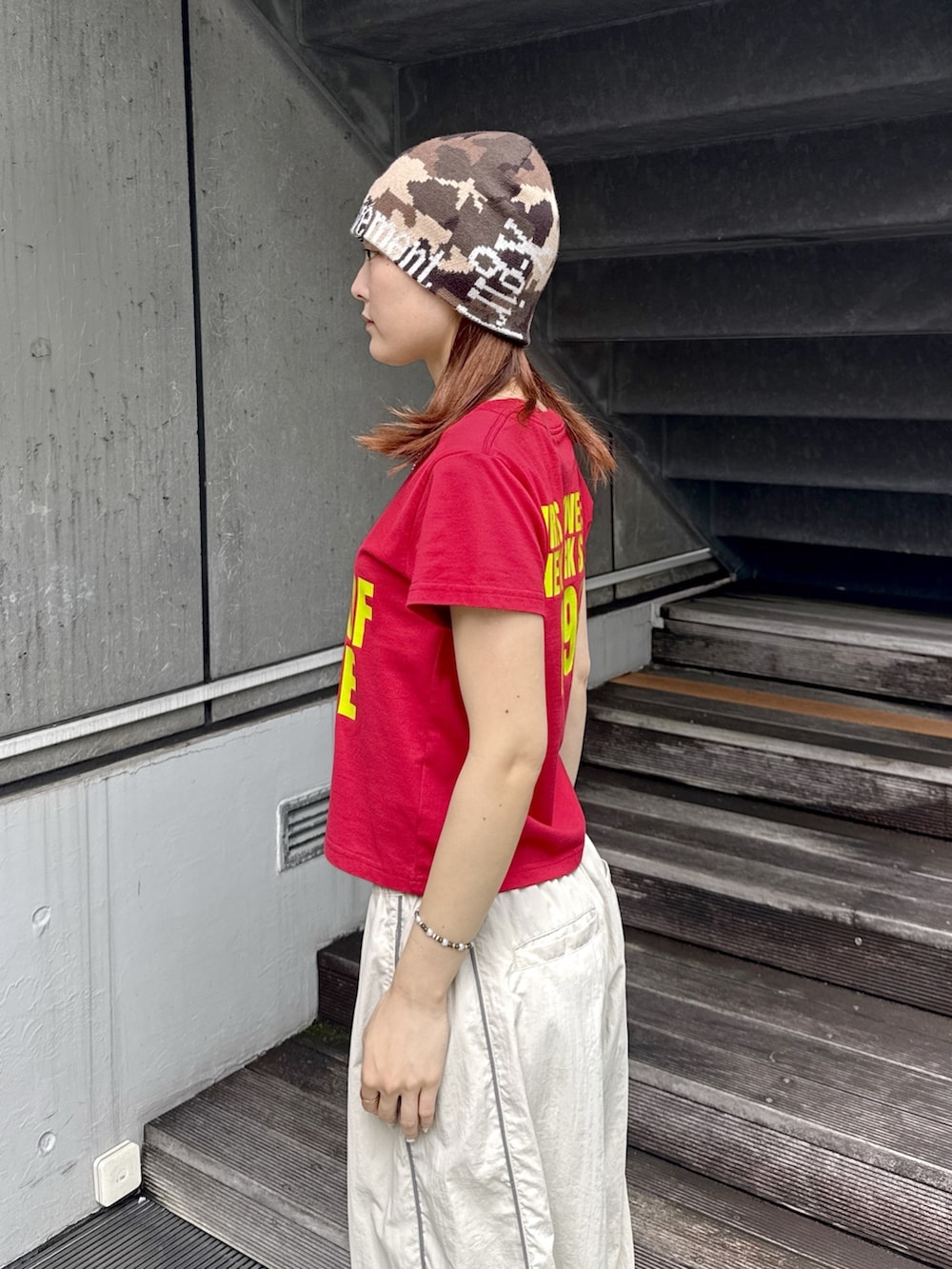 レッド系のTシャツ/カットソー、ベージュ系のその他パンツ、その他のニットキャップ/ビーニーを着用したレディースの夏コーディネートの5枚目の写真