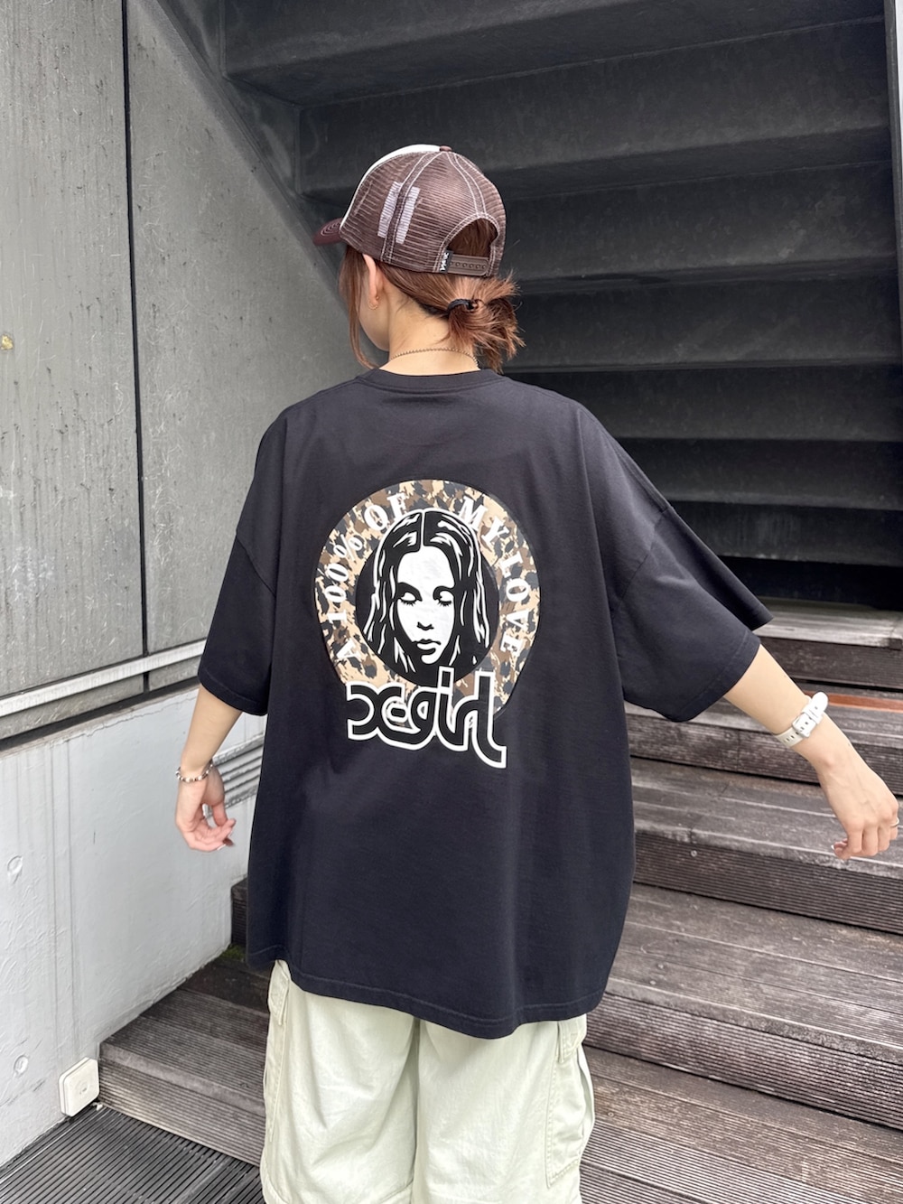 ブラック系のワンピース、ブルー系のデニムパンツ、ベージュ系のショルダーバッグを着用したレディースの夏コーディネートの6枚目の写真