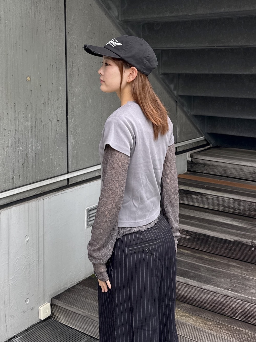 グレー系のTシャツ/カットソー、ブラック系のその他パンツ、ベージュ系のバックパック/リュックを着用したレディースの秋コーディネートの5枚目の写真