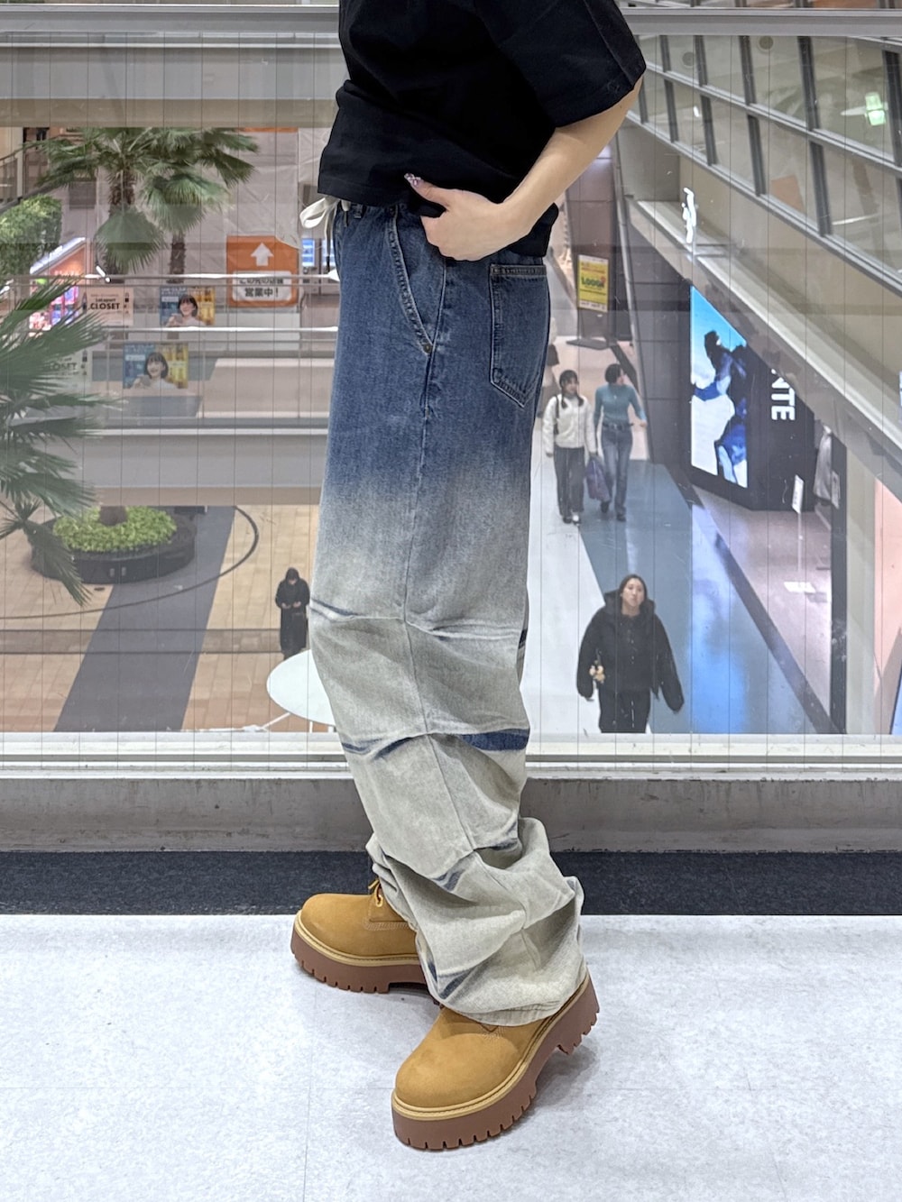 ブラック系のTシャツ/カットソー、グレー系のニット/セーター、ブルー系のデニムパンツを着用したレディースの冬コーディネートの8枚目の写真