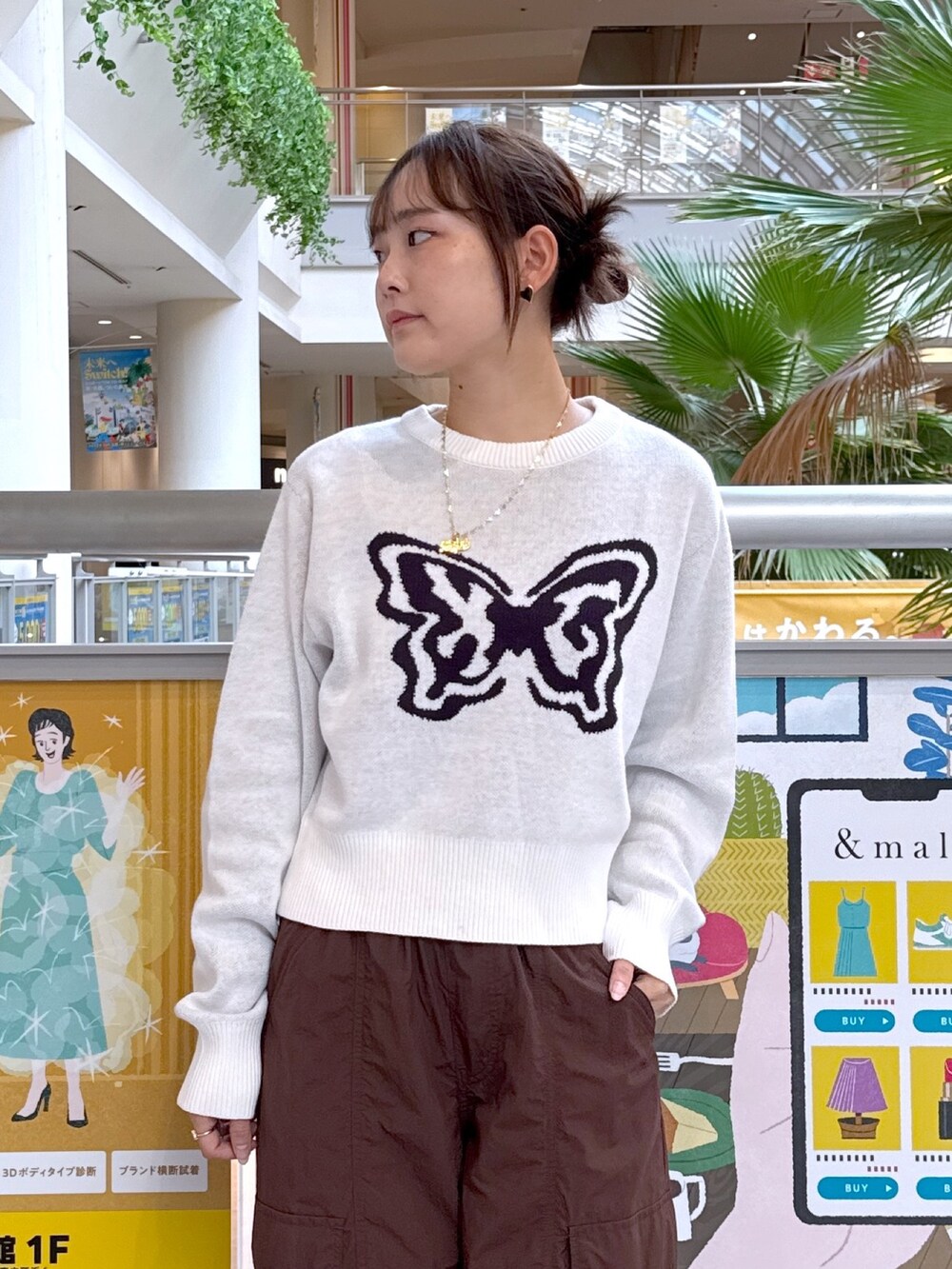 ホワイト系のニット/セーター、ブラウン系のカーゴパンツ、ブラック系のハンドバッグを着用したレディースの秋コーディネートの3枚目の写真