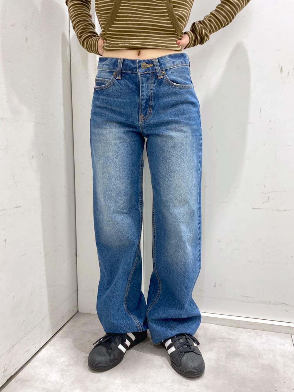 ブラウン系のTシャツ/カットソー、ブルー系のデニムパンツ、ブラック系のショルダーバッグを着用したレディースの冬コーディネートの5枚目の写真