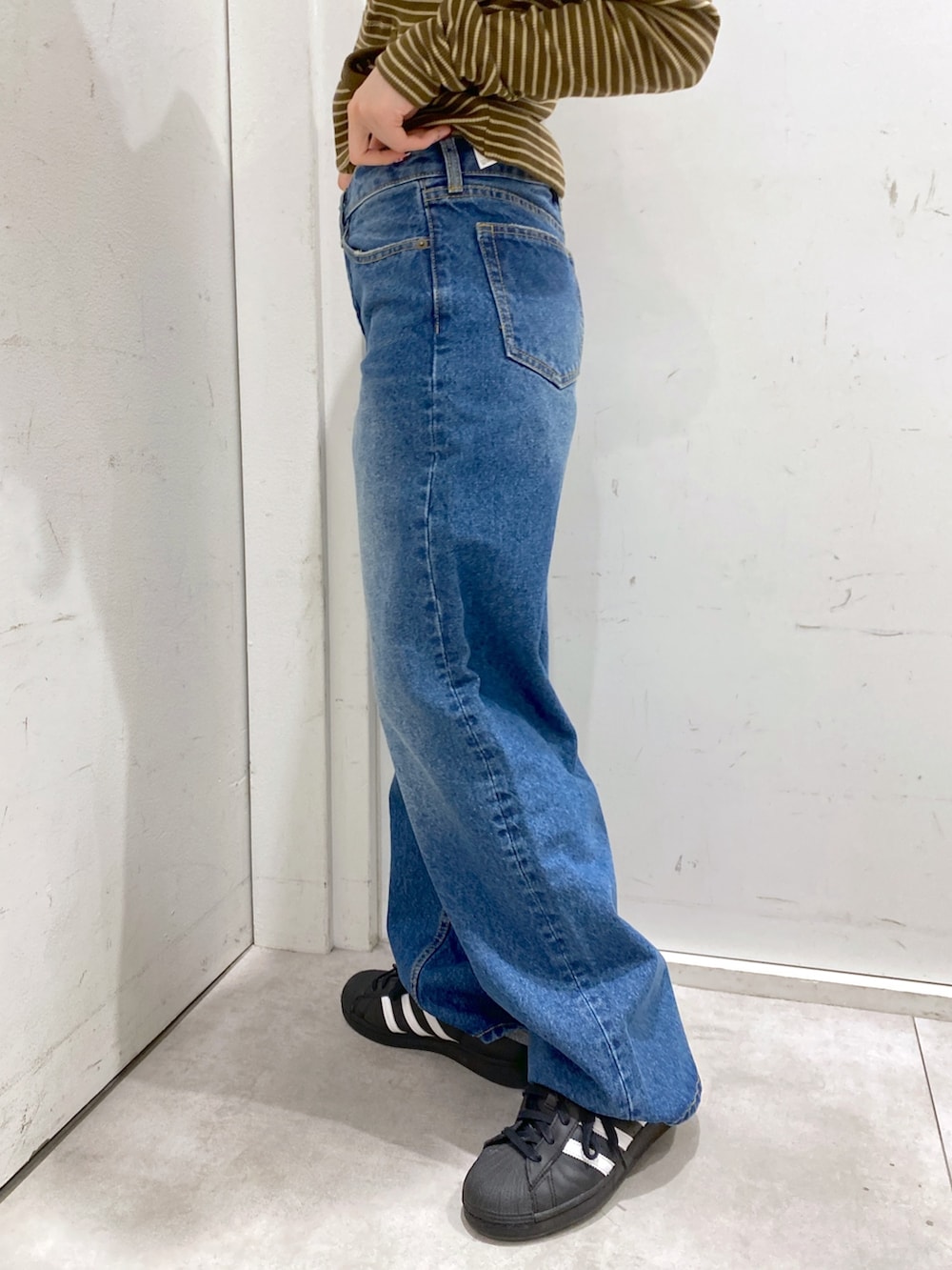 ブラウン系のTシャツ/カットソー、ブルー系のデニムパンツ、ブラック系のショルダーバッグを着用したレディースの冬コーディネートの6枚目の写真