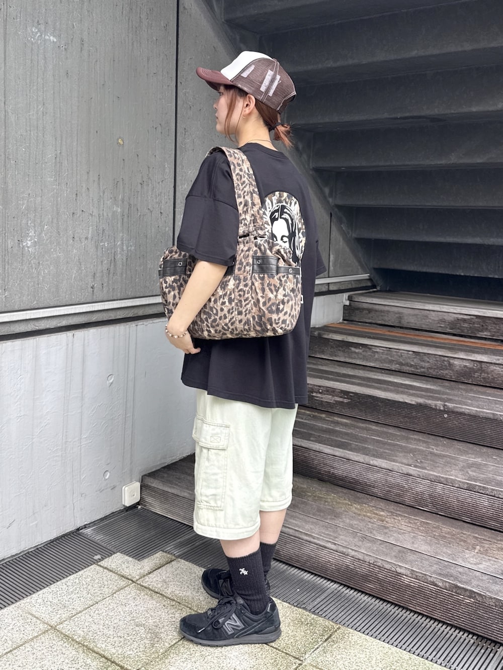 ブラック系のワンピース、ブルー系のデニムパンツ、ベージュ系のショルダーバッグを着用したレディースの夏コーディネートの3枚目の写真
