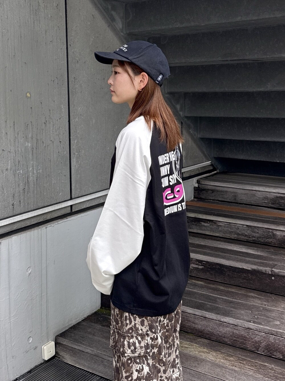 ブラック系のTシャツ/カットソー、ベージュ系のカーゴパンツ、ブラック系のキャップを着用したレディースの秋コーディネートの5枚目の写真