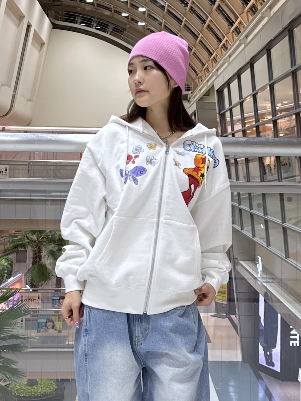 ホワイト系のパーカー、ブルー系のデニムパンツ、ブラック系のショルダーバッグを着用したレディースの冬コーディネートの5枚目の写真