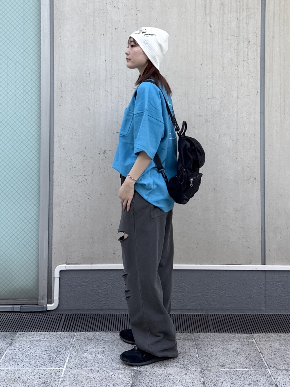 ブラック系のスウェットパンツ、ブルー系のTシャツ/カットソー、ブラック系のバックパック/リュックを着用したレディースの春コーディネートの2枚目の写真